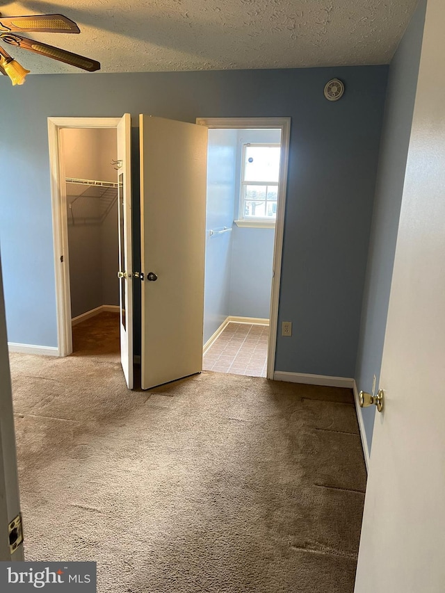 2177 Fawn Ct, Waldorf, MD 20602 - unfurnished bedroom with carpet flooring, a textured ceiling, a walk in closet, and a closet