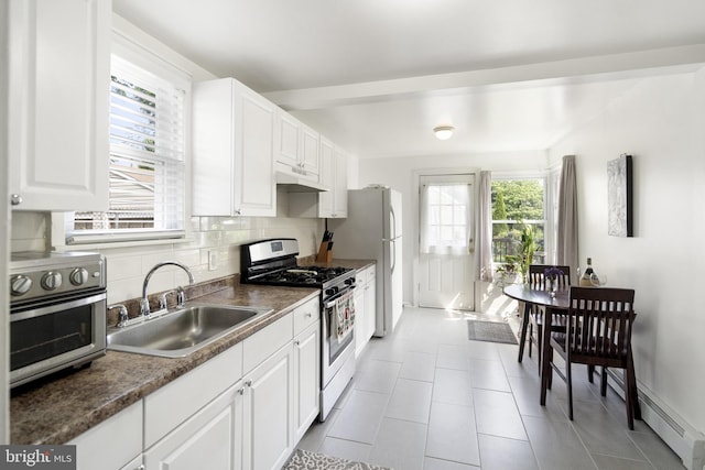 53 Ackerman Ave, Saddle Brook, NJ 07663 - kitchen featuring stainless steel gas range, under cabinet range hood, white cabinets, backsplash, and light tile patterned floors