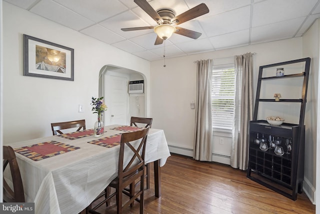 53 Ackerman Ave, Saddle Brook, NJ 07663 - dining room with arched walkways, a paneled ceiling, a baseboard radiator, a ceiling fan, and a wall mounted air conditioner