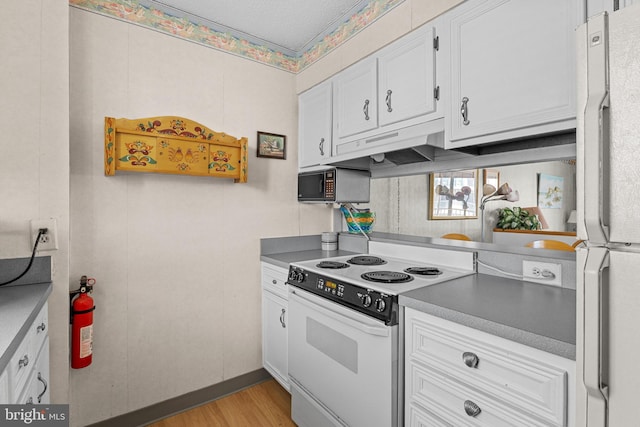 4709 Coastal Hwy Unit 460, Ocean City, MD 21842 - kitchen featuring white appliances, white cabinetry, under cabinet range hood, and light wood-style flooring