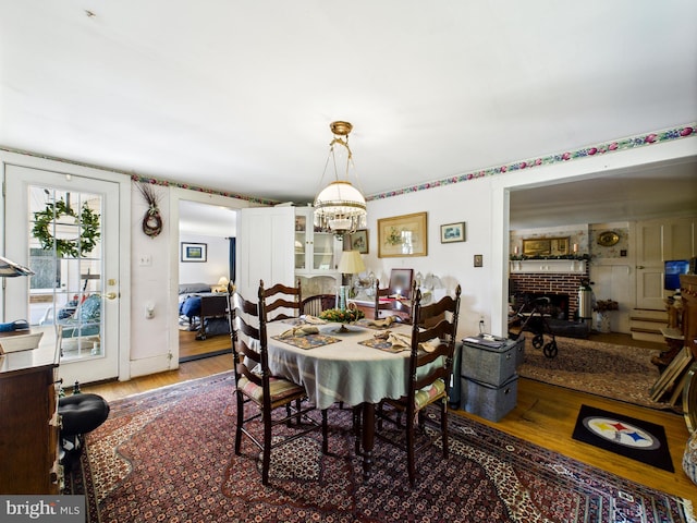 12194 Knife Box Rd, Greensboro, MD 21639 - dining area featuring a chandelier, wood finished floors, and a fireplace
