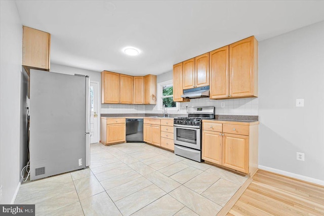 12329 La Plata St, Silver Spring, MD 20904 - kitchen with stainless steel appliances, under cabinet range hood, light brown cabinetry, decorative backsplash, and dark countertops