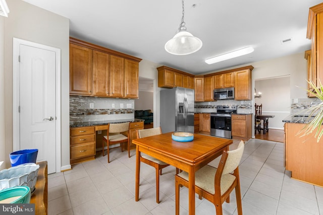 7315 Brookview Rd Unit 306, Elkridge, MD 21075 - kitchen featuring stainless steel appliances, backsplash, dark countertops, and brown cabinetry