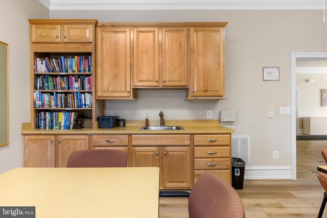 7315 Brookview Rd Unit 306, Elkridge, MD 21075 - kitchen with light countertops, ornamental molding, and light wood-style flooring
