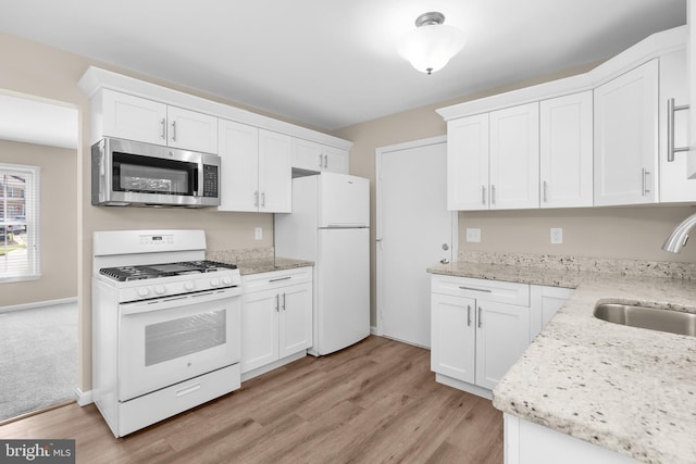 203 Watts Branch Pkwy, Rockville, MD 20850 - kitchen featuring white appliances, light wood-style flooring, white cabinets, and light stone counters