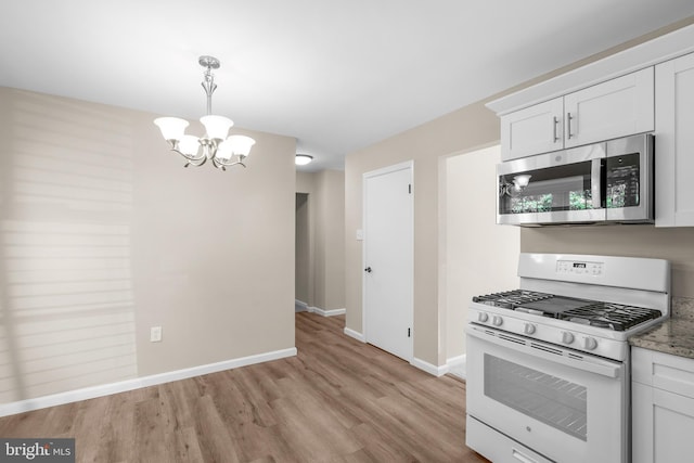 203 Watts Branch Pkwy, Rockville, MD 20850 - kitchen featuring stainless steel microwave, white gas stove, a chandelier, light wood-type flooring, and white cabinets