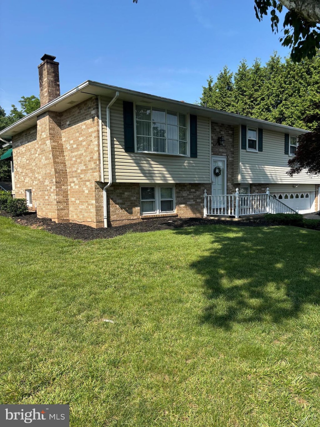 3332 Groton Ln, Dover, PA 17315 - view of front facade featuring a chimney, a front yard, and brick siding