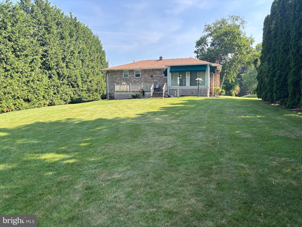 3332 Groton Ln, Dover, PA 17315 - rear view of property with a chimney, brick siding, a yard, and a wooden deck