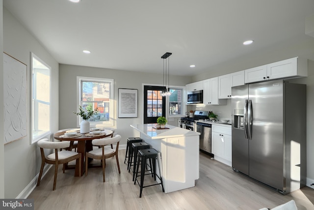 3027 Seamon Ave, Baltimore, MD 21225 - kitchen featuring appliances with stainless steel finishes, a kitchen island, light wood-style flooring, white cabinets, and recessed lighting