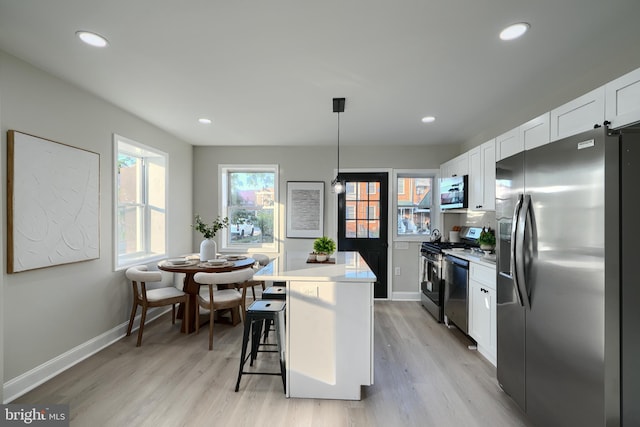 3027 Seamon Ave, Baltimore, MD 21225 - kitchen with stainless steel appliances, white cabinets, light wood-style floors, light countertops, and recessed lighting