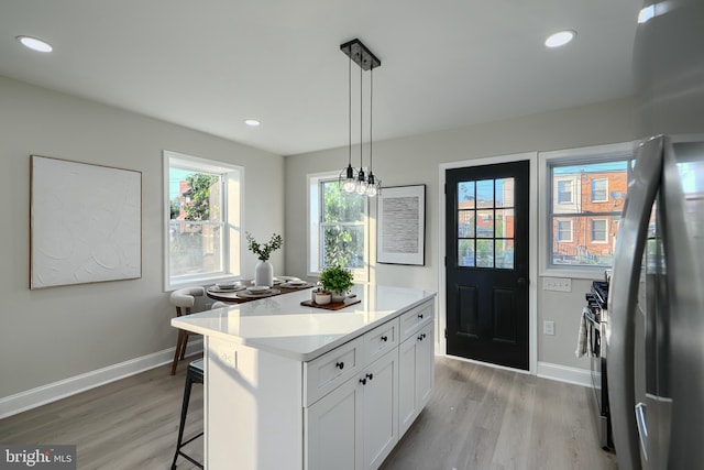 3027 Seamon Ave, Baltimore, MD 21225 - kitchen featuring light wood-style floors, stainless steel appliances, white cabinets, a center island, and recessed lighting