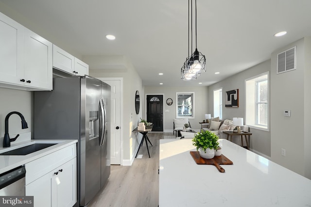 3027 Seamon Ave, Baltimore, MD 21225 - kitchen featuring stainless steel appliances, recessed lighting, white cabinetry, light wood-style floors, and light countertops