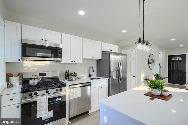 3027 Seamon Ave, Baltimore, MD 21225 - kitchen featuring stainless steel appliances, light countertops, white cabinetry, light wood-type flooring, and recessed lighting