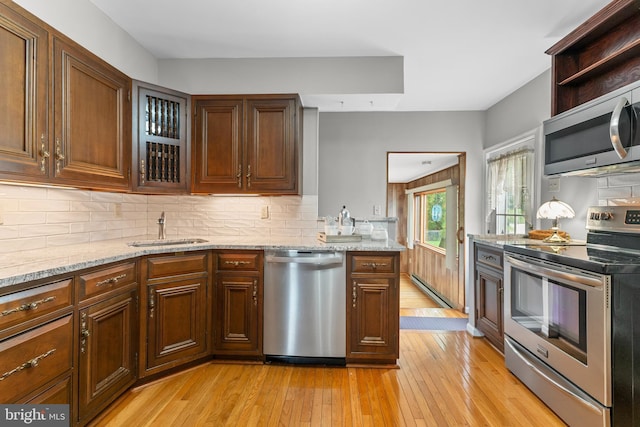 18 Linda Ln, Hatboro, PA 19040 - kitchen with appliances with stainless steel finishes, light wood-style flooring, backsplash, and light stone counters