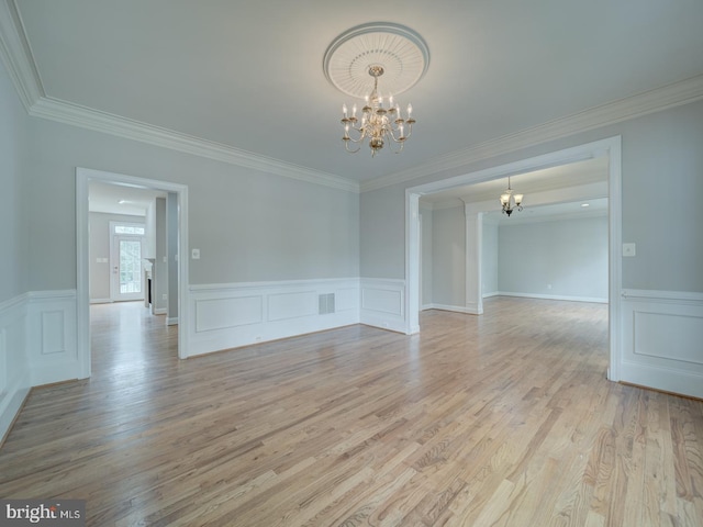 8429 Link Hills Loop, Gainesville, VA 20155 - spare room featuring a chandelier, ornamental molding, light wood-style floors, wainscoting, and a decorative wall