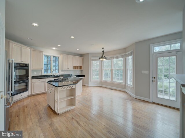 8429 Link Hills Loop, Gainesville, VA 20155 - kitchen with open shelves, light wood-style floors, dark countertops, a center island, and recessed lighting