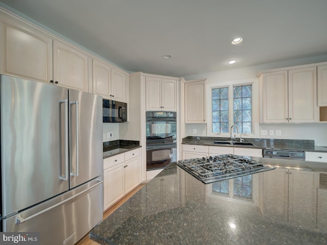 8429 Link Hills Loop, Gainesville, VA 20155 - kitchen featuring black appliances, dark stone countertops, cream cabinets, and recessed lighting