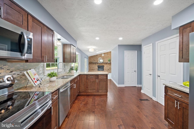 6112 Hillview Ct, Manassas, VA 20112 - kitchen with stainless steel appliances, tasteful backsplash, dark wood-style floors, light stone counters, and a peninsula
