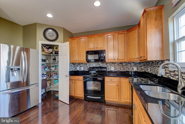 2018 Silver Bell Ct, Culpeper, VA 22701 - kitchen with black appliances, dark wood finished floors, dark stone counters, backsplash, and recessed lighting