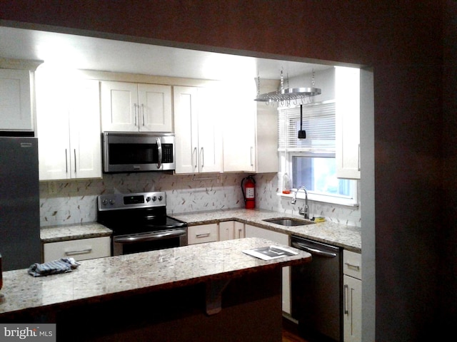 1209 Idylwood Rd, Pikesville, MD 21208 - kitchen with appliances with stainless steel finishes, white cabinets, tasteful backsplash, and light stone countertops