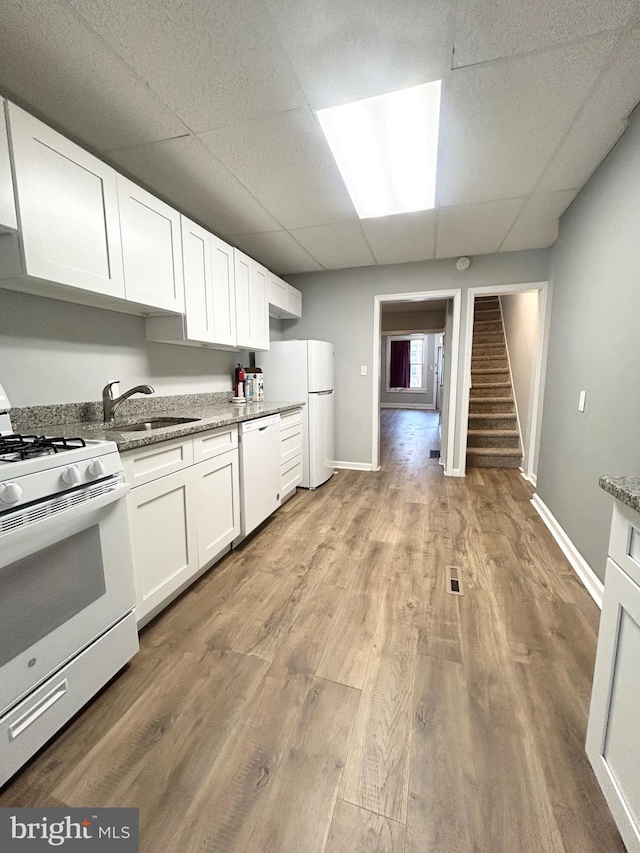 533 Franklin St, West Reading, PA 19611 - kitchen featuring white appliances, a paneled ceiling, light wood-style floors, white cabinetry, and light stone countertops