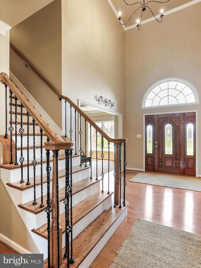 22124 Whitestone Ct, Smithsburg, MD 21783 - foyer featuring a chandelier, wood finished floors, a towering ceiling, stairway, and ornamental molding