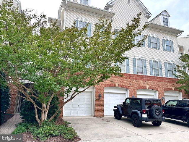 8980 Harrover Pl Unit 80B, Lorton, VA 22079 - townhome / multi-family property with driveway, brick siding, and an attached garage