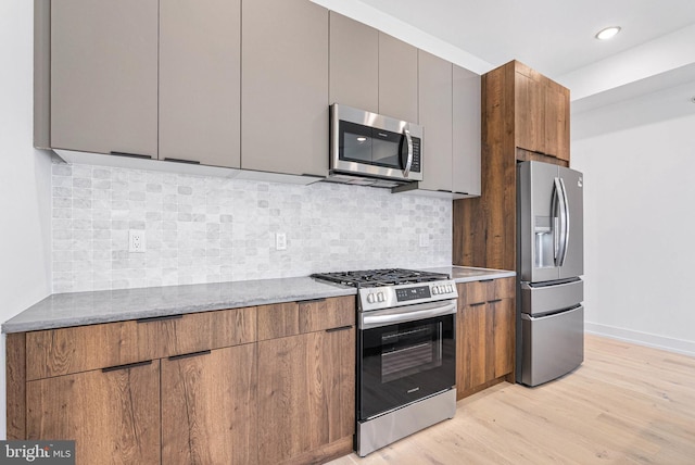 1338 N Franklin St, Philadelphia, PA 19122 - kitchen with stainless steel appliances, light wood-style floors, modern cabinets, decorative backsplash, and stone counters