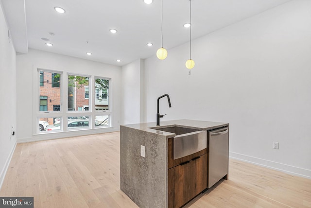 1338 N Franklin St, Philadelphia, PA 19122 - kitchen with stainless steel dishwasher, light wood-style flooring, an island with sink, hanging light fixtures, and stone countertops