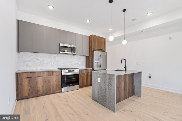 1338 N Franklin St, Philadelphia, PA 19122 - kitchen with appliances with stainless steel finishes, light wood-style floors, decorative backsplash, hanging light fixtures, and recessed lighting