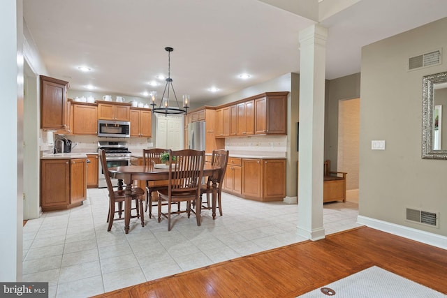 16 Fox Hollow Dr, Lancaster, PA 17602 - dining space with light tile patterned floors, a chandelier, and decorative columns