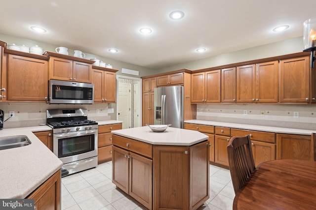 16 Fox Hollow Dr, Lancaster, PA 17602 - kitchen featuring appliances with stainless steel finishes, light tile patterned floors, brown cabinets, a kitchen island, and recessed lighting