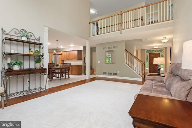 16 Fox Hollow Dr, Lancaster, PA 17602 - living area featuring a high ceiling, stairs, light wood-style flooring, and a chandelier