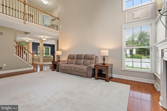 16 Fox Hollow Dr, Lancaster, PA 17602 - living room featuring hardwood / wood-style floors, a towering ceiling, stairs, ornate columns, and a fireplace