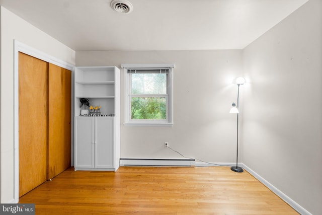 643 Meadow Branch Rd, Westminster, MD 21158 - unfurnished bedroom featuring a baseboard radiator, wood finished floors, and a closet