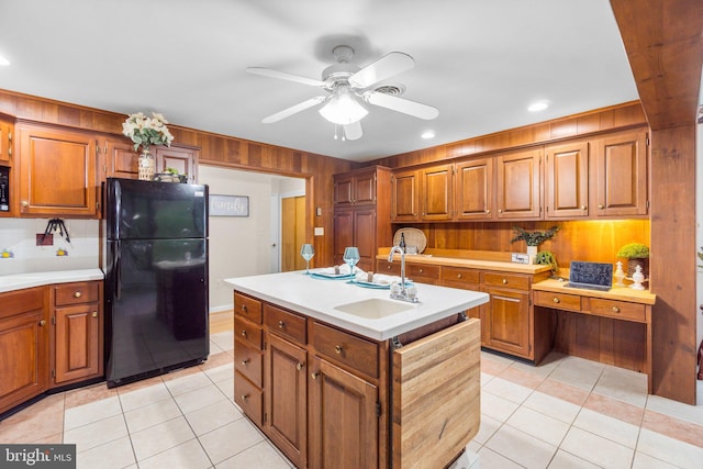643 Meadow Branch Rd, Westminster, MD 21158 - kitchen featuring freestanding refrigerator, light countertops, light tile patterned floors, brown cabinets, and wooden walls