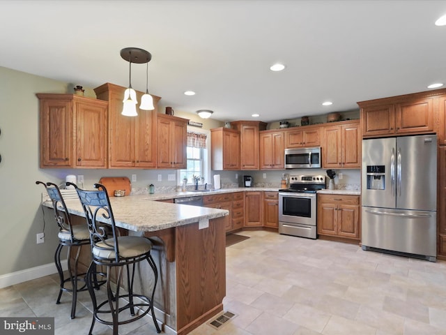 647 Warm Spring Rd, Chambersburg, PA 17202 - kitchen featuring stainless steel appliances, a peninsula, brown cabinets, light countertops, and recessed lighting