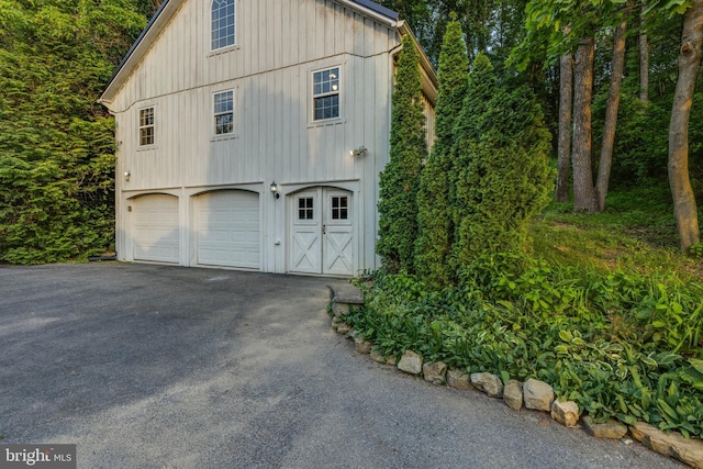 1801 Stringtown Rd, Sparks Glencoe, MD 21152 - view of side of home featuring board and batten siding, an attached garage, and asphalt driveway