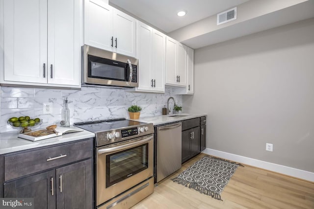 505 Kennedy St NW Unit 6-302, Washington, DC 20011 - kitchen with appliances with stainless steel finishes, white cabinetry, light countertops, backsplash, and recessed lighting