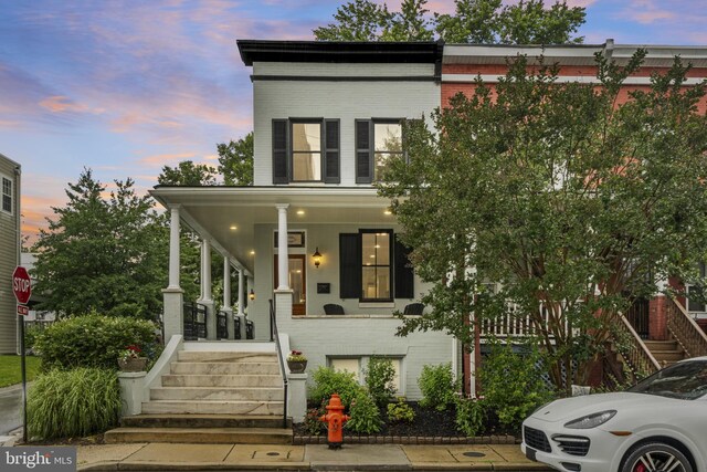 4300 Evans Chapel Rd, Baltimore, MD 21211 - view of front of property featuring covered porch, stairs, and brick siding