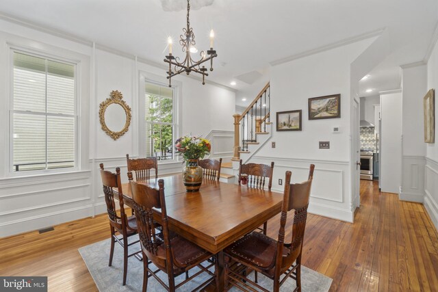 4300 Evans Chapel Rd, Baltimore, MD 21211 - dining room with a decorative wall, a chandelier, light wood finished floors, wainscoting, and stairs