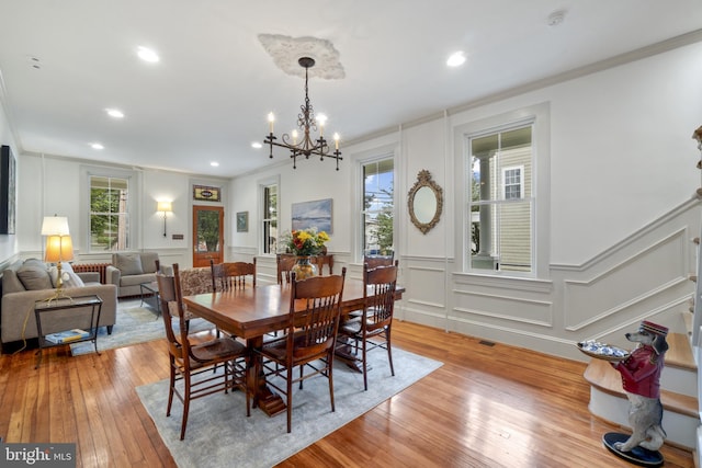 4300 Evans Chapel Rd, Baltimore, MD 21211 - dining space featuring a decorative wall, plenty of natural light, a chandelier, light wood-style flooring, and crown molding