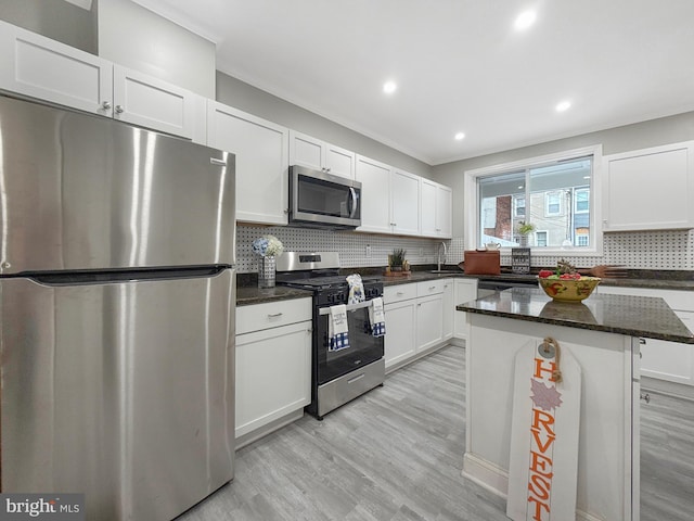 1180 Cleveland St, Baltimore, MD 21230 - kitchen with stainless steel appliances, white cabinetry, light wood-type flooring, backsplash, and recessed lighting