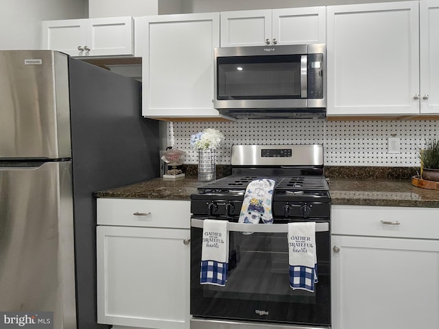 1180 Cleveland St, Baltimore, MD 21230 - kitchen featuring stainless steel appliances, white cabinets, tasteful backsplash, and dark stone counters