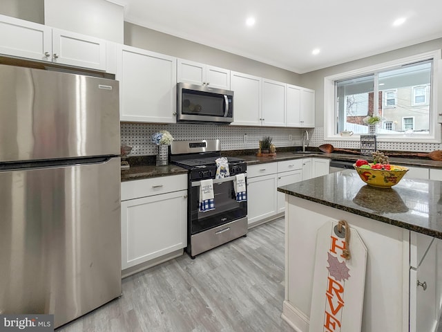 1180 Cleveland St, Baltimore, MD 21230 - kitchen with stainless steel appliances, white cabinets, backsplash, recessed lighting, and crown molding