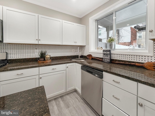 1180 Cleveland St, Baltimore, MD 21230 - kitchen with stainless steel dishwasher, white cabinetry, light wood-style flooring, dark stone counters, and tasteful backsplash