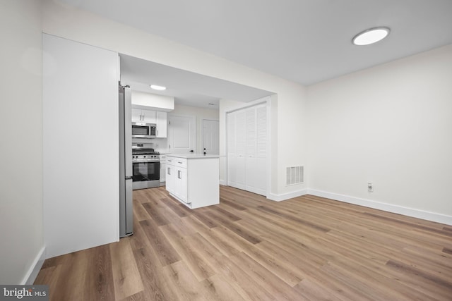 400 Reservoir St, Trenton, NJ 08618 - kitchen with stainless steel appliances, light countertops, light wood-style flooring, white cabinetry, and a center island