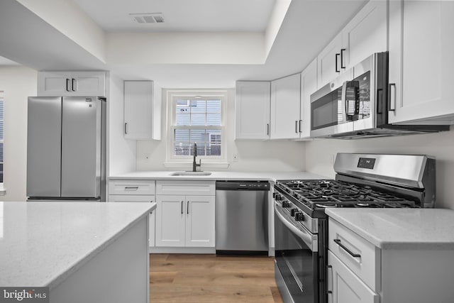 400 Reservoir St, Trenton, NJ 08618 - kitchen with appliances with stainless steel finishes, white cabinetry, light wood-style flooring, and light stone counters