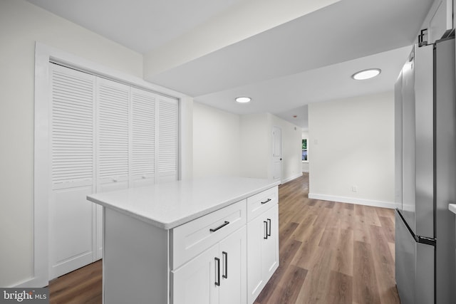 400 Reservoir St, Trenton, NJ 08618 - kitchen featuring freestanding refrigerator, white cabinetry, light countertops, wood finished floors, and a center island