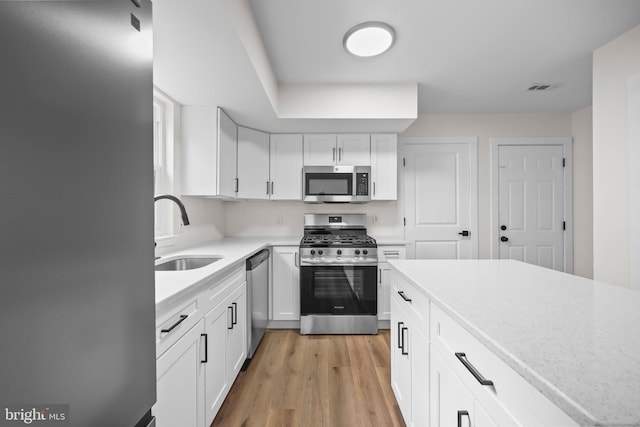 400 Reservoir St, Trenton, NJ 08618 - kitchen featuring appliances with stainless steel finishes, light countertops, white cabinets, and light wood-style flooring